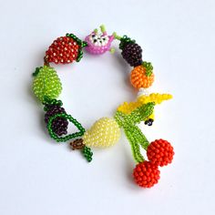 the beaded bracelet has fruit and vegetables on it