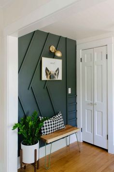 a room with green walls and a bench in the corner, next to a white door