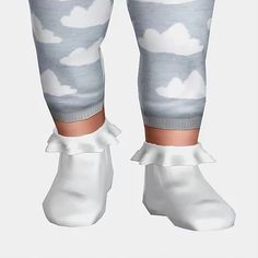 the legs and ankles of a child wearing white socks with clouds on them, all in grey