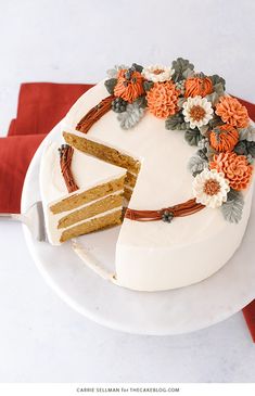 the cake is decorated with flowers and has a slice taken out of it on the plate