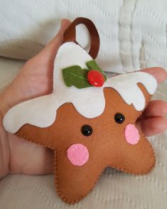 a hand holding a brown and white christmas ornament