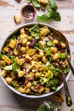 a bowl filled with pasta and spinach salad