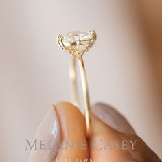 a woman's hand holding an engagement ring with a diamond in the middle and side