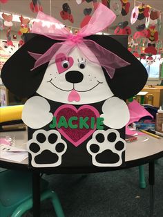 a black and white dog with a pink heart on it's chest sitting in front of a table