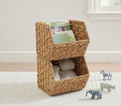 a toy elephant and two stuffed animals in a wicker basket on a white rug