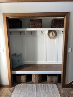 a mudroom with baskets and hats on the shelves, next to a rug in front of it