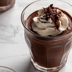 there is a chocolate dessert with whipped cream and chocolate shavings in it on the table