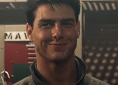 a man standing in front of a locker with his hand on his hip and smiling at the camera