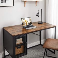 a laptop computer sitting on top of a wooden desk next to a brown leather chair