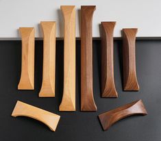 several wooden pieces are arranged on a black surface with white walls in the back ground