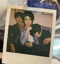 an old photo of two young men sitting next to each other on top of a table