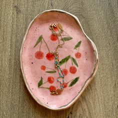 a pink bowl with beads and flowers on it