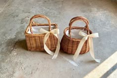 two wicker baskets with bows on the ground