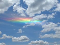 a rainbow appears in the sky over a field