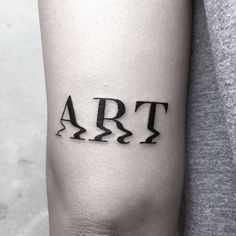 a woman's arm with the word art on it and an arrow in black ink