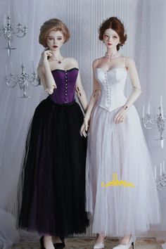 two mannequins dressed in black and white dresses, one wearing a purple corset