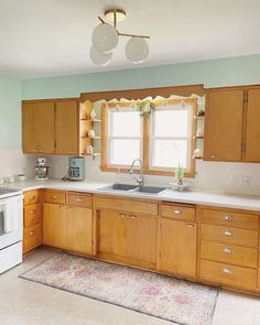 a kitchen with light wood cabinets and white stove top oven, dishwasher and microwave