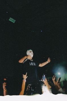 a man standing on top of a stage surrounded by people