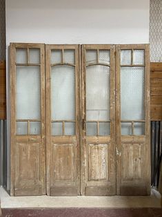 an old wooden double door with glass panels