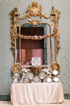 a table with a mirror on top of it and some dishes in front of it