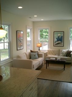 a living room filled with furniture and windows