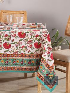 a table with a floral design on it and two glasses sitting on top of the table