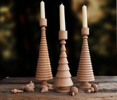 three wooden candlesticks sitting next to each other on top of a wood table