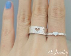 a woman's hand with a heart ring on it