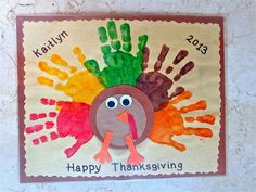 a turkey handprinted with happy thanksgiving written on the front, and hands painted in different colors