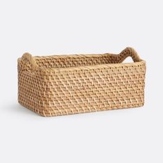 a woven rectangular basket with handles on the bottom and sides, made from wicker