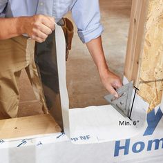 a man sanding down the side of a wooden structure with a trowel