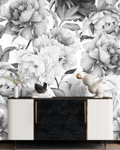 a black and white floral wallpaper mural in a living room with a sideboard