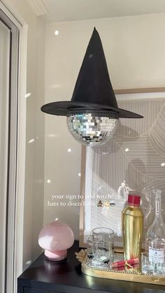 a mirror ball hanging from the ceiling above a table with bottles and glasses on it