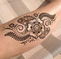 a woman's arm with a henna tattoo on her left arm and an intricate flower