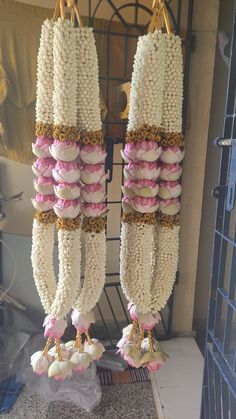 two rows of macaroni hanging from hooks in front of a door with other macaroni and rice decorations on it