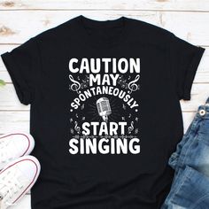 a t - shirt that says caution may be an antaneous start singing