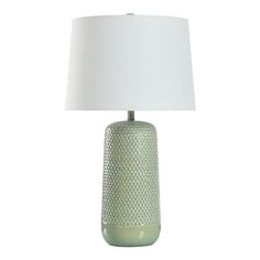 a green table lamp with a white shade on the base and a light blue vase