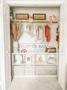 an open closet with clothes hanging on the wall and other items in bins next to it