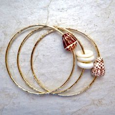 "3 Hawaiian Shell Bangles~ 3 beautiful Hawaiian shell bangles hammered and polished for that extra sparkle. Perfect gift for the beach lover! *This listing is for 3 custom made 14k gold fill 12 gauge (thick) hammered bangles with your choice of shells. If you are ordering a small or extra small bangle you may want to choose a shell from the second picture with smaller shells* **Made with 14k gold fill thick 12 gauge wire, thicker than 14 gauge.** Please view the last picture on this listing that Gold Green Necklace, Shell Bangles, Shells Craft, Hammered Bracelet, Hammered Bangles, Formal Jewelry, Hawaii Style, Handmade Gold Jewellery, Bangle Gold