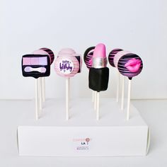 four cake pops with pink and black designs on them