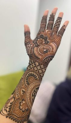 a woman's hand with henna tattoos on it