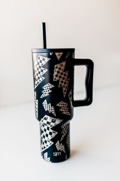 a black and white coffee cup with a straw in it