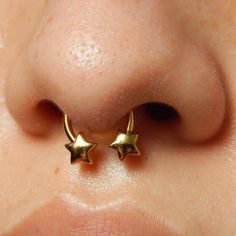 a close up of a person's nose with two gold stars on the side