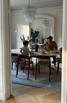 a man sitting at a table with two children