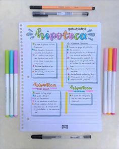 a notebook with some writing on it next to markers and pens in front of them