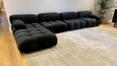 a large black couch sitting on top of a wooden floor