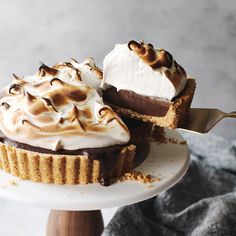 two desserts sitting on top of a white cake plate