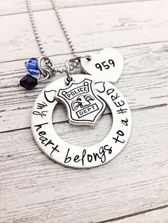 "Beautiful hand stamped Police Officer wife gift. This police officer gift is hand stamped with my heart belongs to a hero. Comes with a hand stamped heart for the police badge number or name if you prefer.  Comes adorned with a small police badge charm and blue and black beads to represent the thin blue line. This makes a perfect gift for a police officer mom,  gifts for police officers, police girlfriend or police graduation. All items come packaged ready for gift giving. Hand stamping is done Gifts For Police Officers, Police Girlfriend, Police Graduation, Police Officer Wife, Wife Tattoo, Police Gifts, Police Officer Gifts, Police Wife, Wife Necklace