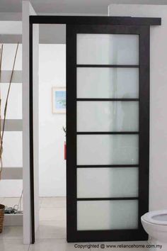 an open glass door in a room with white walls and black trimmings on the doors