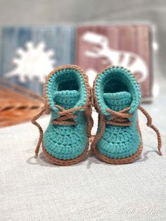 a pair of crocheted baby shoes sitting on top of a bed